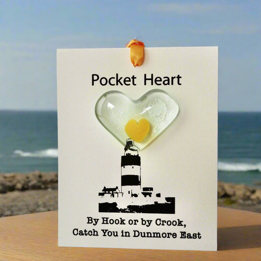 Heart-shaped object with a lighthouse design on a card labeled 'Pocket Heart'.